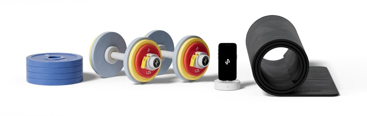 Tempo Core Plus bundle: a stack of plates, two dumbbells with colour-coded plates, the phone dock and a rolled mat.